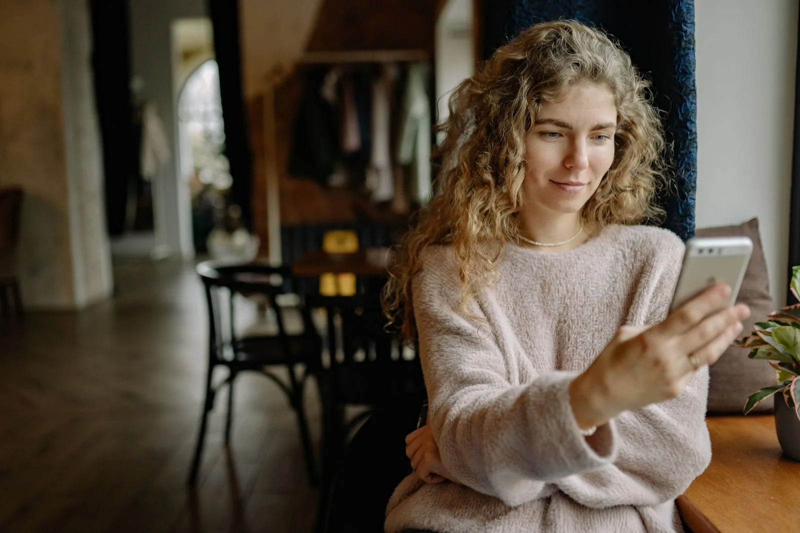 A woman at home checks information on her phone.